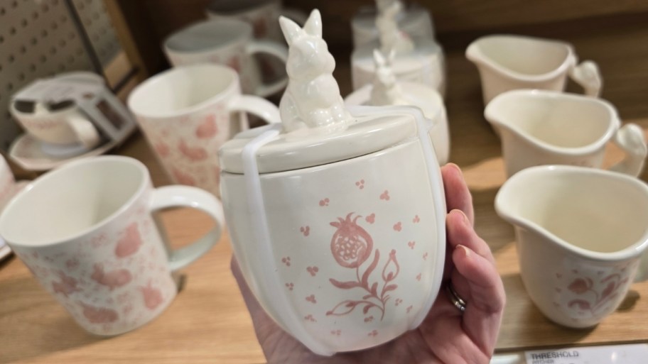 womans hand holding a hand painted sugar jar