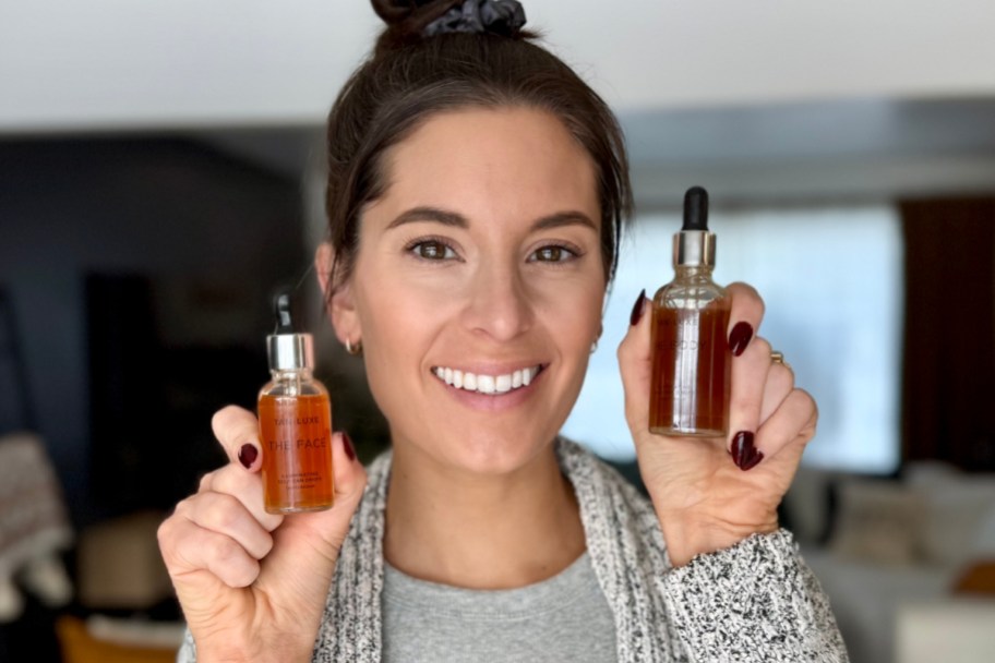 woman holding two jars of tan drops