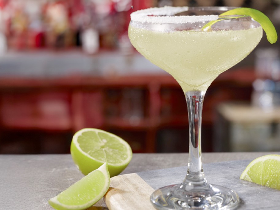 lime margarita on table with limes