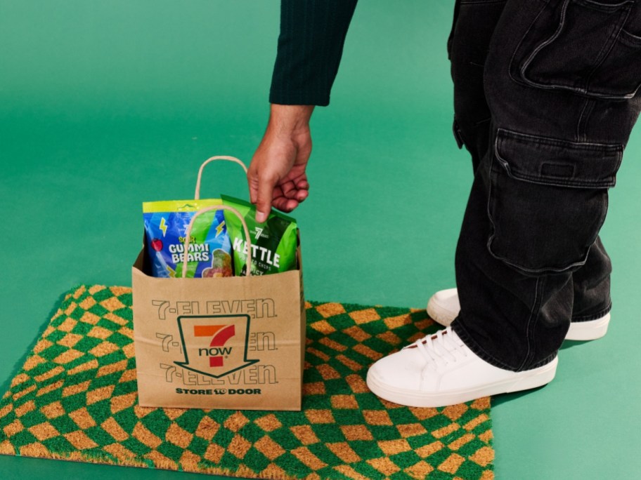 pulling snacks from a 7 Eleven paper bag