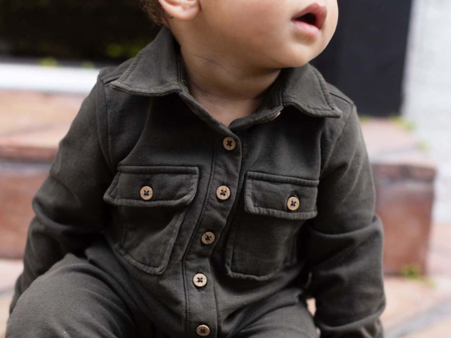 Burts bees baby boy wearing jumpsuit set while sitting down 