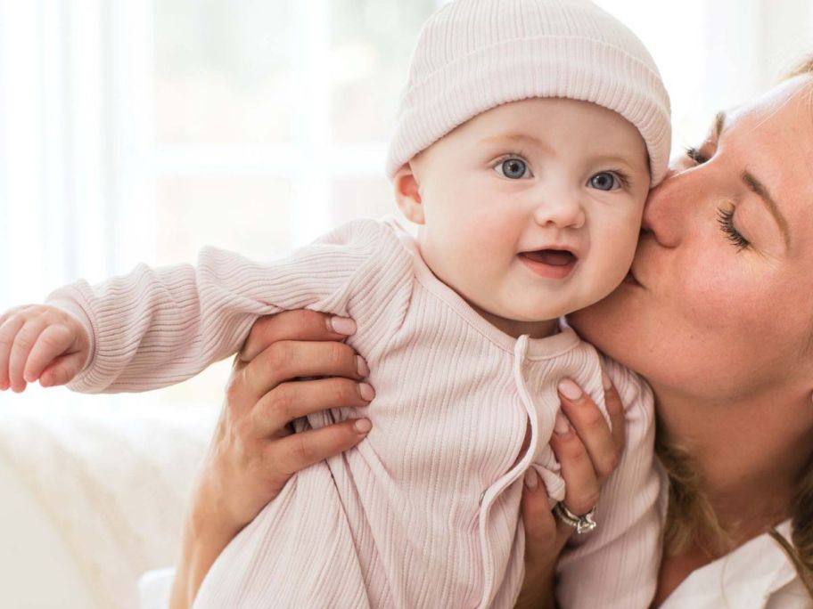 Burts bees baby girl in pink set being held by her mom