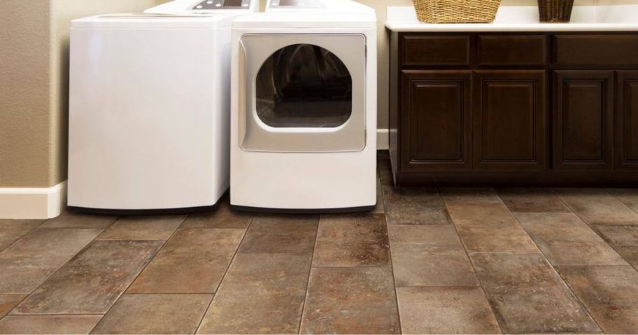 A laundry room with a brown tiled floor