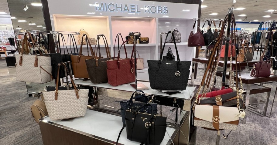 a display of Michael Kors purses and bags in a store