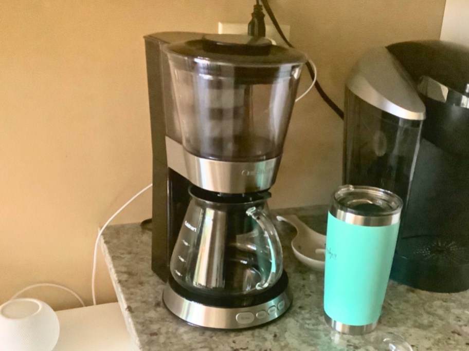 a cold brew coffee maker, a coffee tumbler, and a Keurig coffee maker on a counter