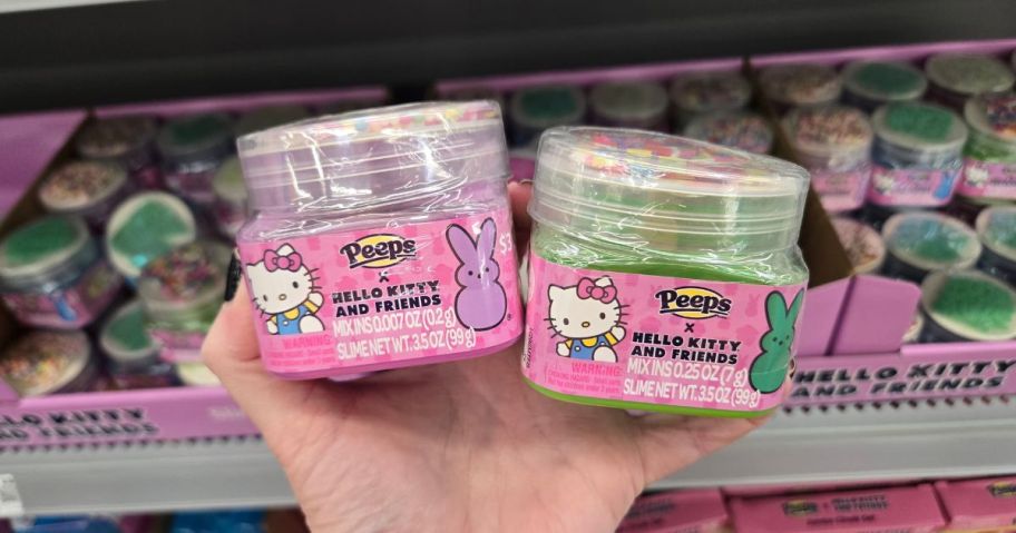 A person holding two Hello Kitty x Peeps Easter Slime canisters at Walmart