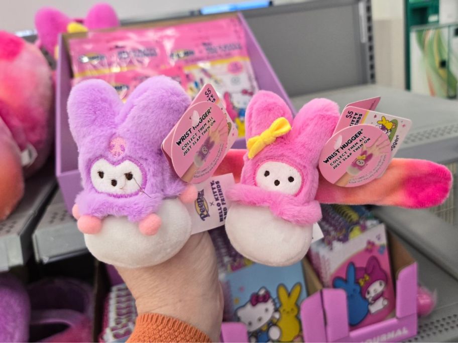 A person holding two Hello Kitty x Peeps Easter Wrist Hugger at Walmart