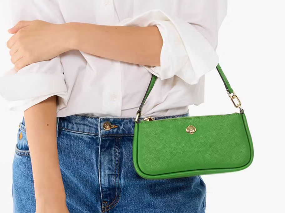 A woman carrying a green purse 