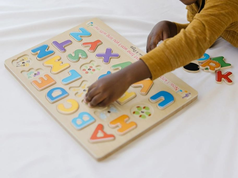 A child playing with Melissa & Doug Wooden Alphabet