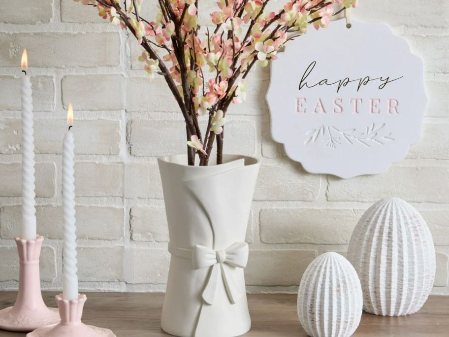 A vase. candles, and other Easter decor on a table