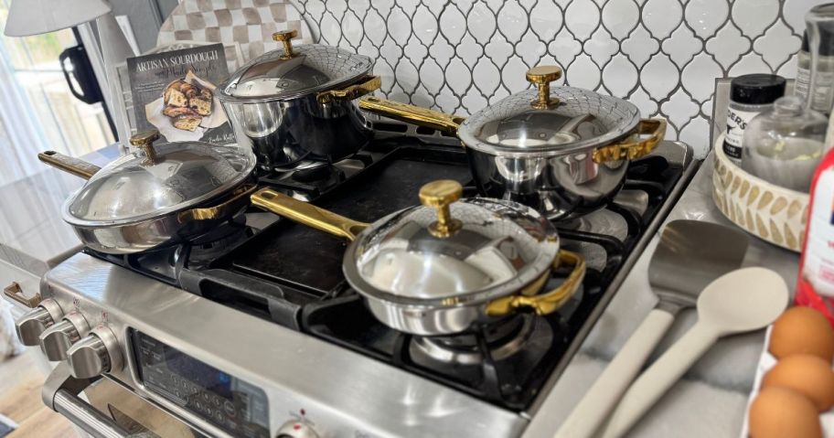 Several cooking pans and pots on a stove top