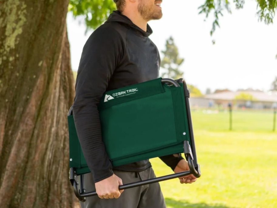 man carrying a folded Ozark Trail Stadium Seat