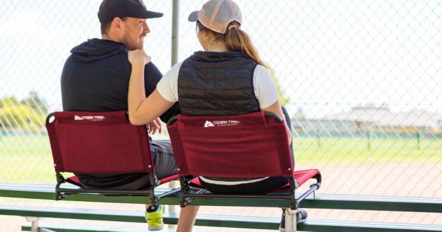 A man and a woman sitting in Ozark Trail Stadium Seats on outdoor bleachers