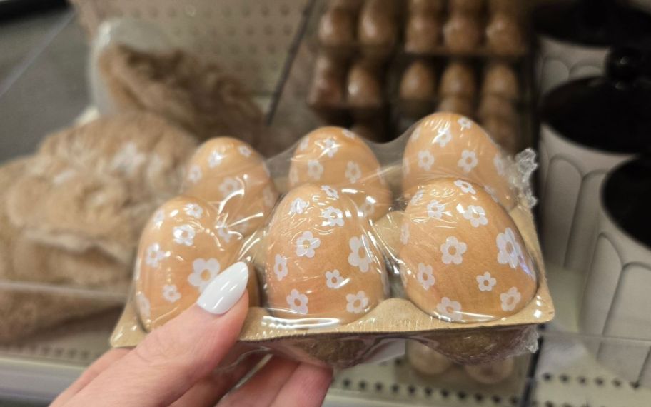 hand holding a set of wood eggs