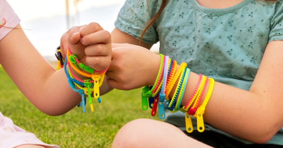 two girls wearing colorful zipper bracelets