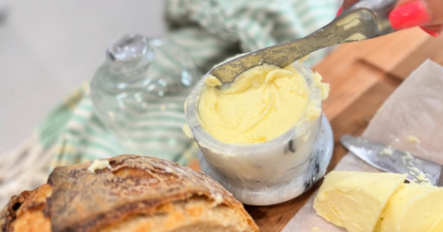 marble butter dish with homemade butter on a cutting board 