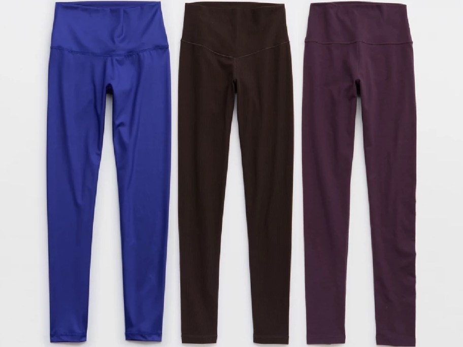 Three pairs of leggings in blue, brown, and dark purple colors.