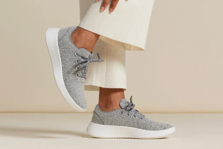 woman wearing grey sneakers and white pants