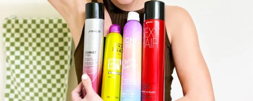 woman holding 4 bottles of hair spray