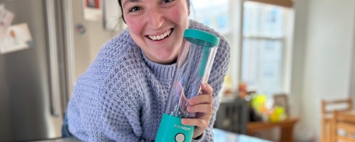 woman holding teal blender