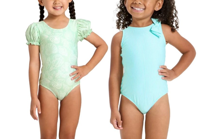 Two young girls smiling in swimsuits. The left girl wears a light green suit with puffed sleeves; the right girl wears a light blue sleeveless suit.