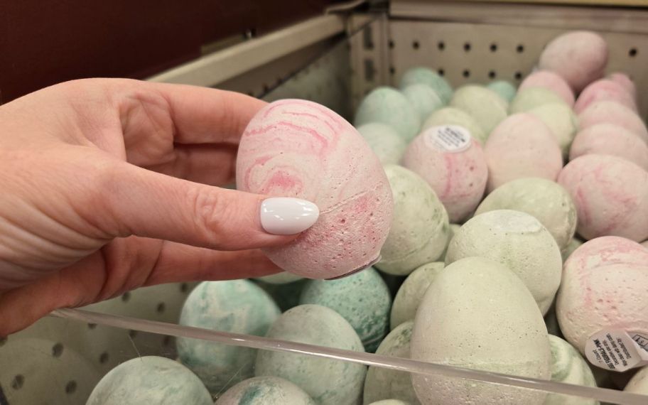 hand holding ceramic eggs in different colors 