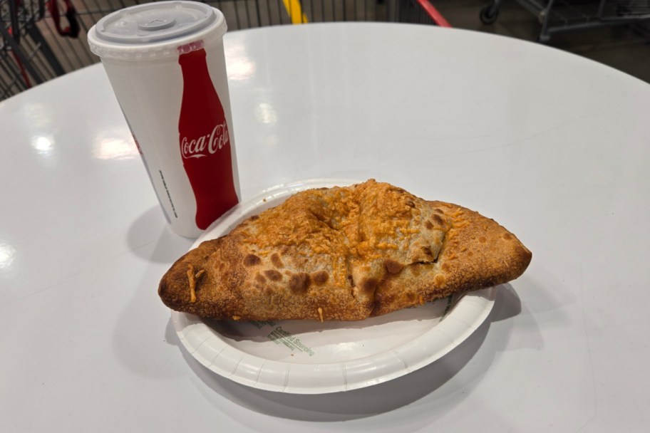 calzone on plate next to coca cola