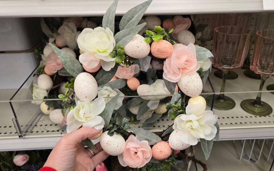 hand holding egg and floral wreath
