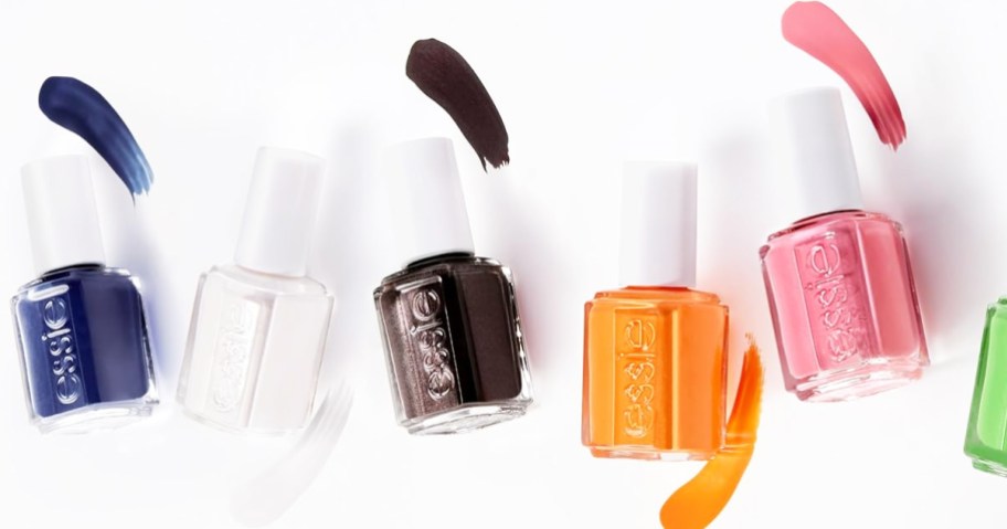 multiple bottles of essie nail polish with color swatches next to them