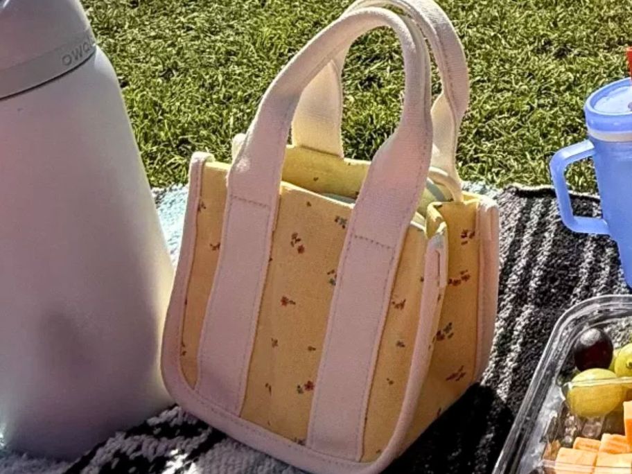 flower purse displayed on top of a blanket on grass