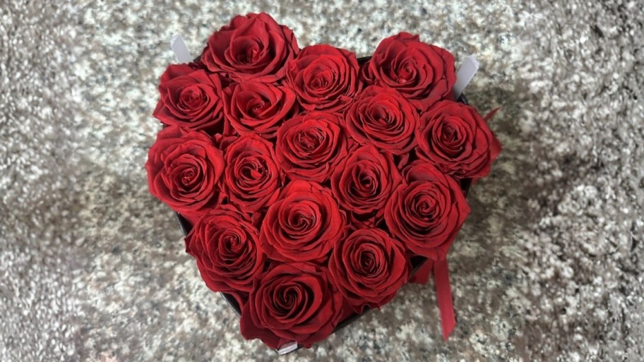 a heart shaped box of red roses