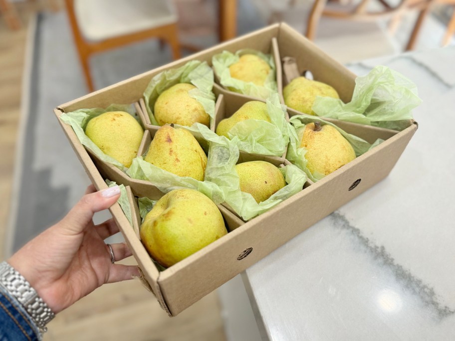 hand holding box of pears