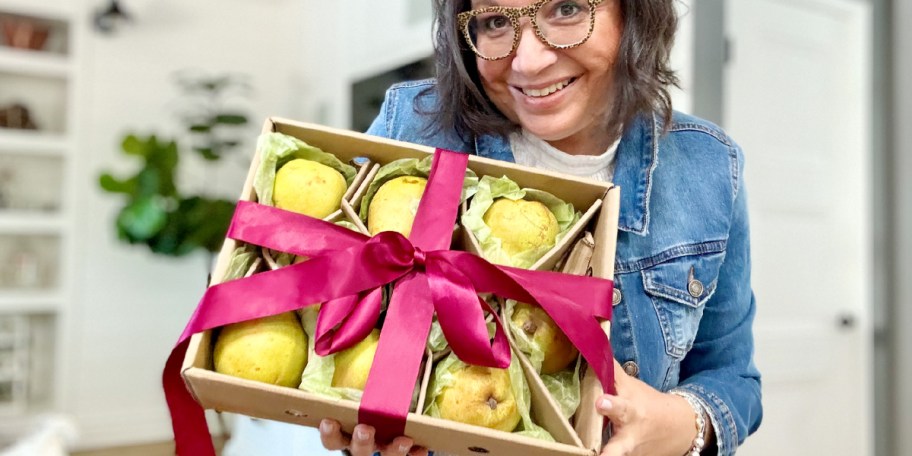 woman holding box of pears with red bow