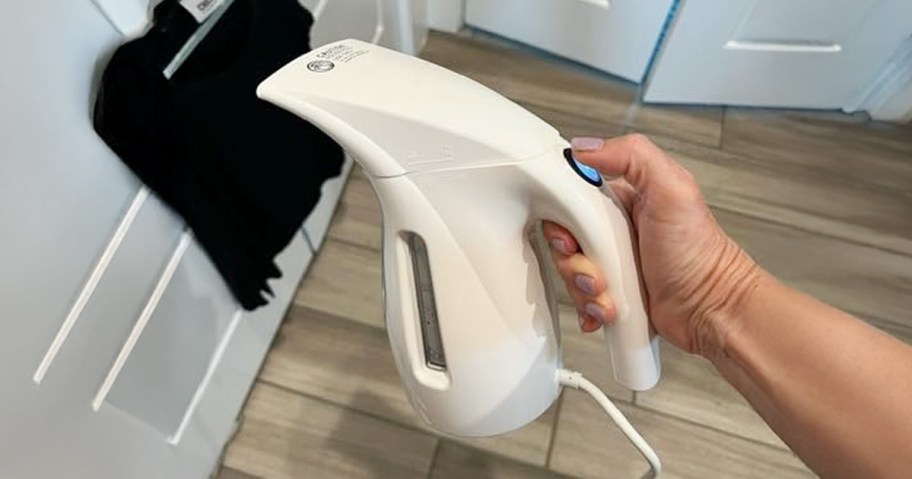 person using steamer on a black shirt