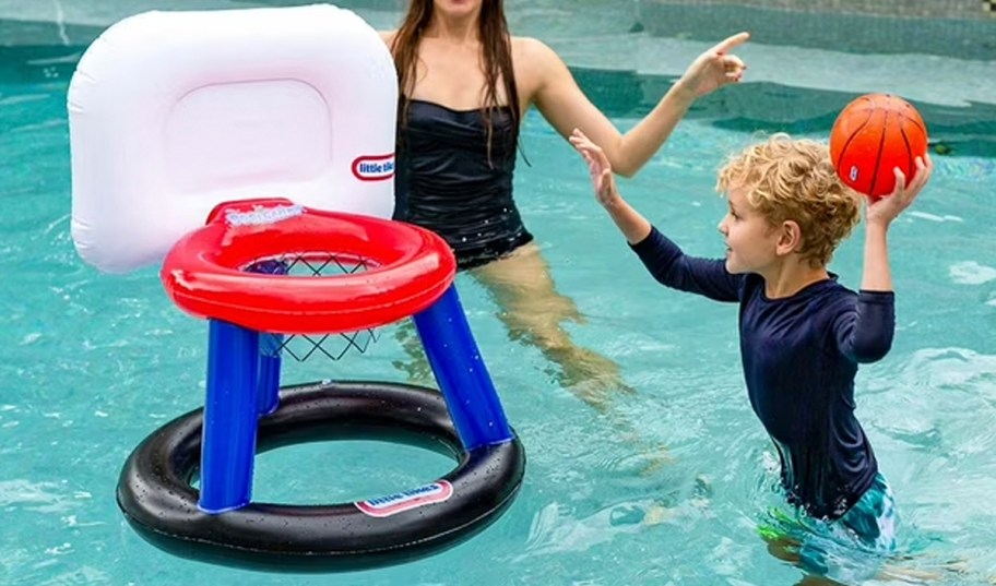 child playing with inflatable basketball hoop in pool 
