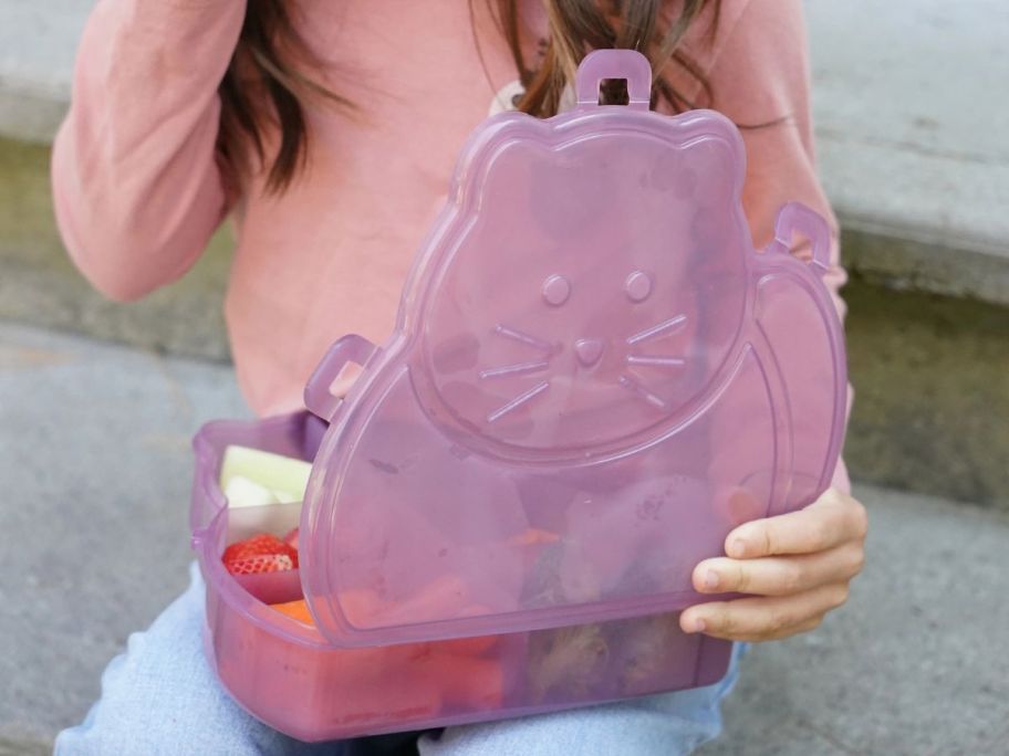 girl holding purple cat shaped snackle box