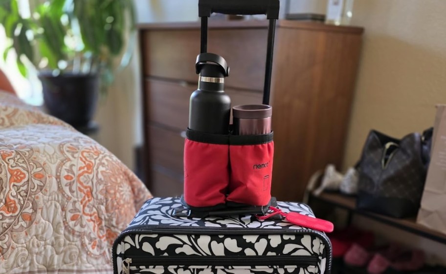 cup holder on top of black and white suitcase