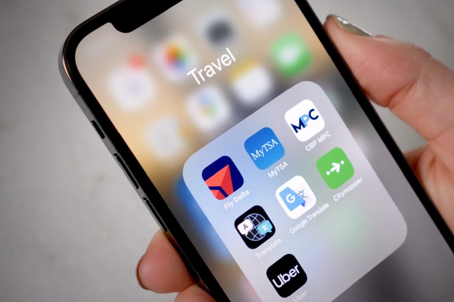 hand holding phone showing travel apps