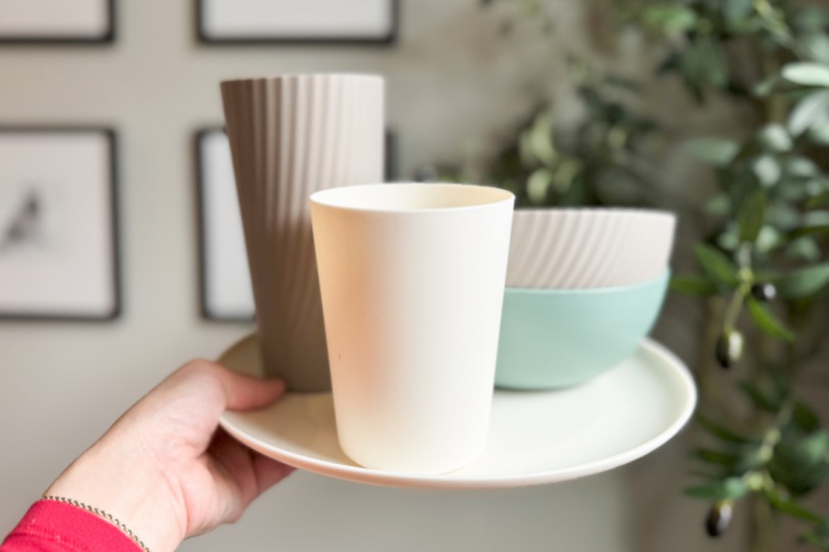 hand holding stack of plastic dishes