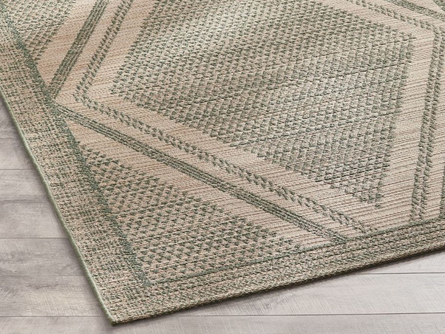 sage colored diamond shape designed Better Homes & Gardens 7' x 10' Outdoor Rug on floor