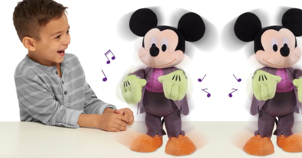 Disney Mickey Mouse plush standing on countertop in front of little boy