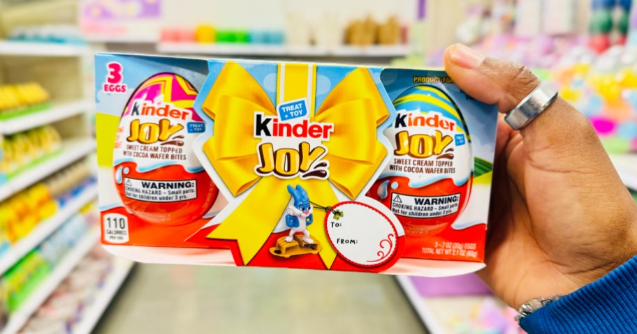 hand holding a 3-pack of Kinder Joy Easter Eggs in store