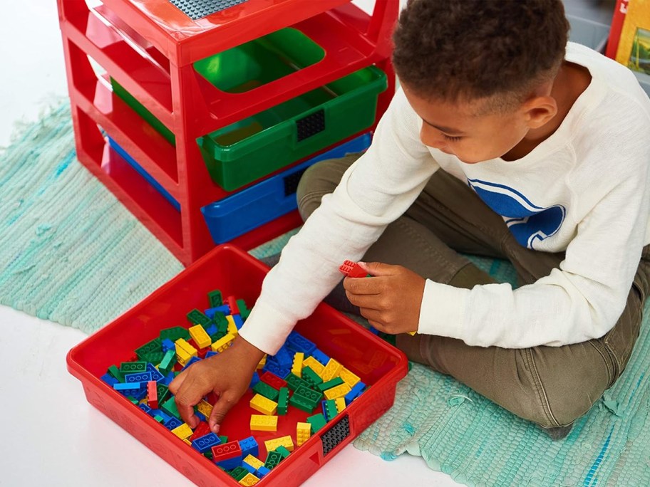 boy grabbing legos out of a red storage box