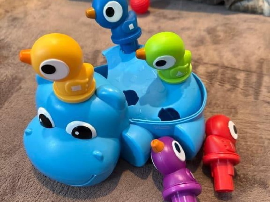 Learning Resources Huey the Fine Motor Hippo toy with colorful bird pieces sitting on and around the blue hippopotamus base.