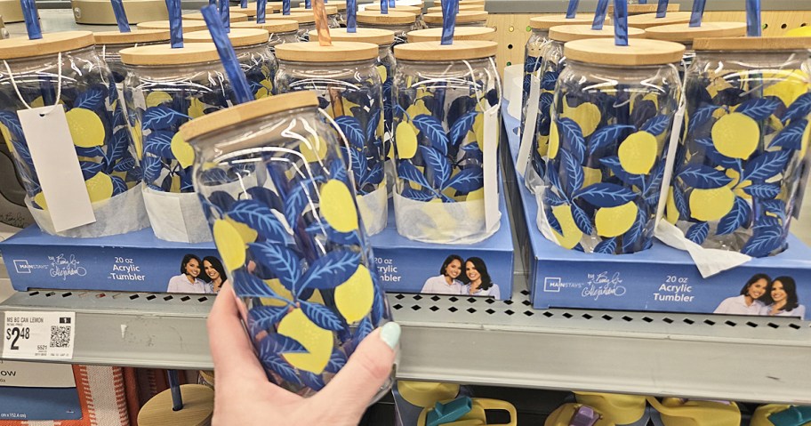 hand holding up a blue and yellow lemon print tumbler