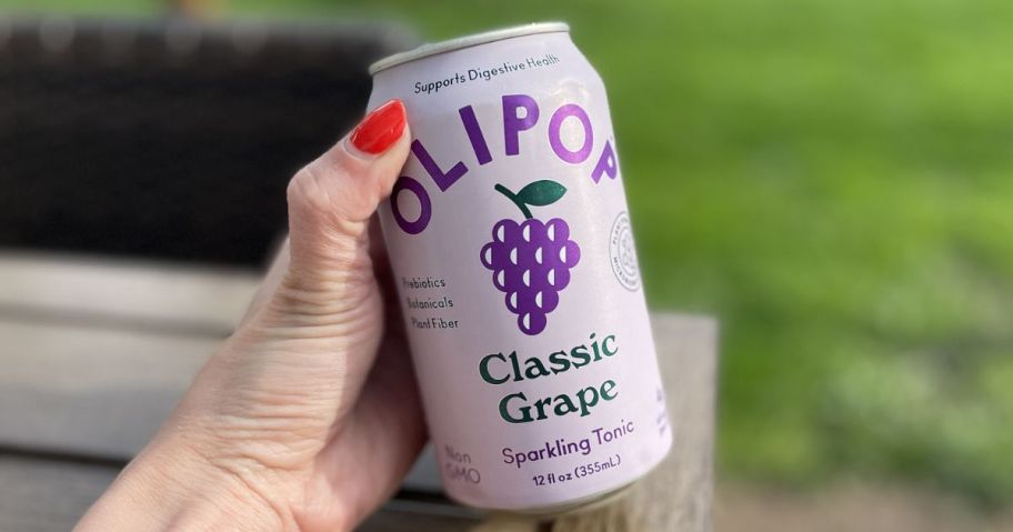 Hand holding a can of grape olipop