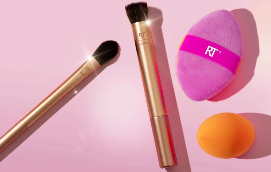 Real Techniques brushes and sponges on a pink background