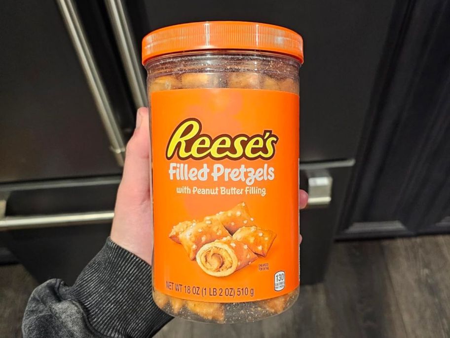 A person holding a Reese's Filled Pretzels 18oz Jar