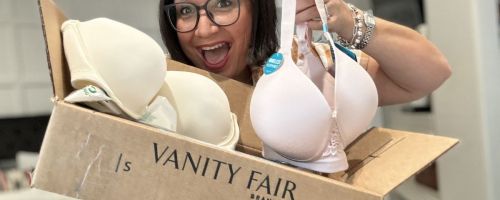 Woman holding cardboard shipping box with two Vanity Fair bras in it