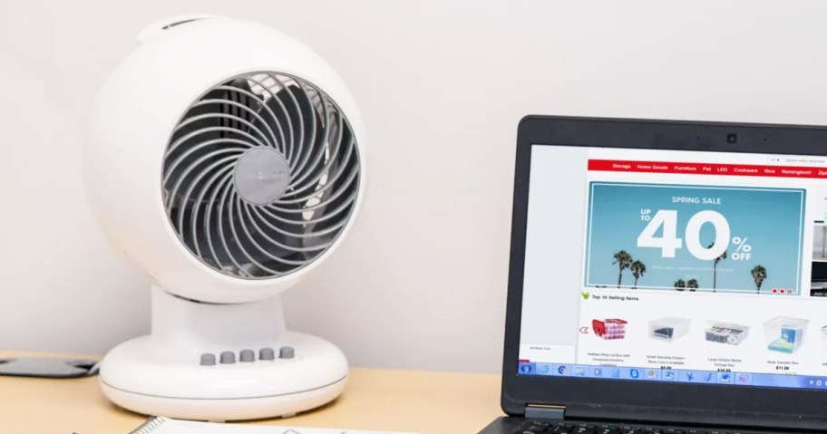 round white fan on a desk near a laptop
